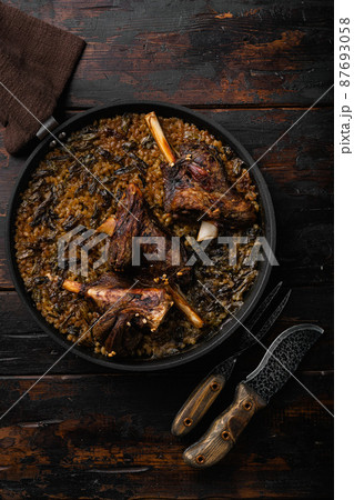 Baked lamb shank meat, on old dark wooden table background, top view flat lay Baked lamb shank meat, on old dark wooden table background, top view flat lay 87693058