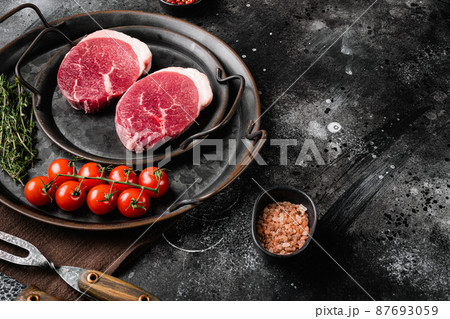 Fresh raw organic beef steak, on black dark stone table background, with copy space for text Fresh raw organic beef steak, on black dark stone table background, with copy space for text 87693059