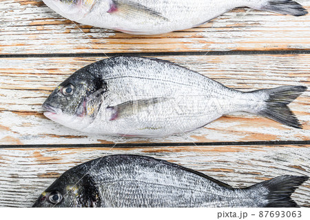 Set of raw whole dorado or Gilt head bream fish over white wood table top view 87693063