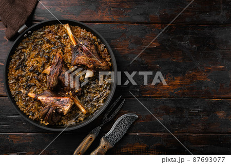 Baked whole lamb shanks meat, on old dark wooden table background, top view flat lay, with copy space for text Baked whole lamb shanks meat, on old dark wooden table background, top view flat lay, with copy space for text 87693077