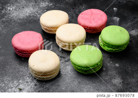 Colorful french macarons, on black dark stone table background Colorful french macarons, on black dark stone table background 87693078