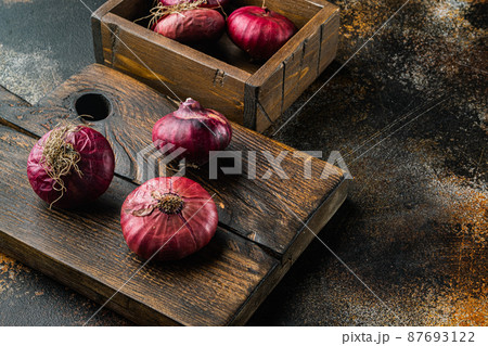 Red onions, on old dark rustic background with copy space for text Red onions, on old dark rustic background with copy space for text 87693122
