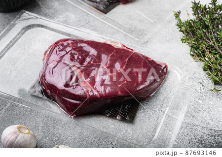 Pack with fresh rump beef steak, on gray stone table background Pack with fresh rump beef steak, on gray stone table background 87693146