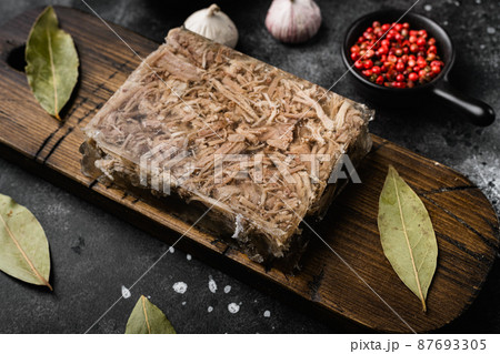 Jellied meat, on black dark stone table background Jellied meat, on black dark stone table background 87693305