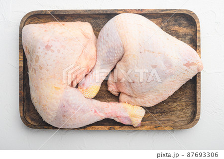 Chicken brow and drumstick with skin, on wooden tray, on white stone background, top view flat lay 87693306