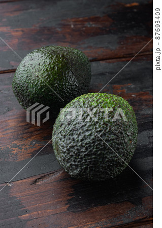 Whole pair of green avocado, on old wooden table Whole pair of green avocado, on old wooden table 87693409
