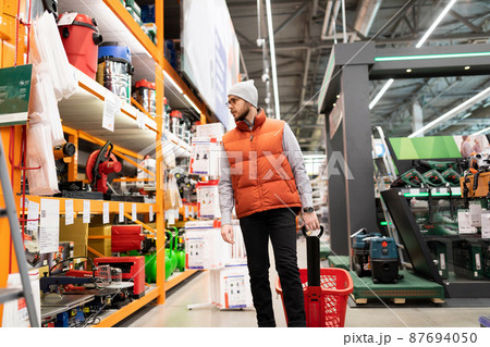 a man in a hardware store does not choose an air compressor and gas generator a man in a hardware store does not choose an air compressor and gas generator 87694050