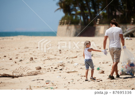Father and Daughter Cleaning Beach 87695336