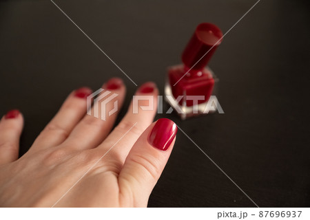 Woman hand with red nail polish on fingernails. Beauty treatment and hand care, manicure procedure 87696937