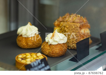 Variety baked shu cakes, tarts and kiev cake in glass showcase at bakery cafe. Variety baked shu cakes, tarts and kiev cake in glass showcase at bakery cafe. 87698762