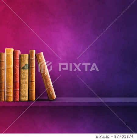 Row of old books on purple shelf. Square background 87701874