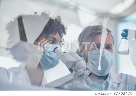 female scientist in a protective mask works in a laboratory . female scientist in a protective mask works in a laboratory . 87702470