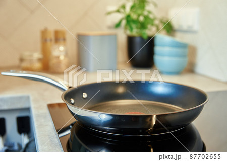 Frying pan on induction hob at kitchen 87702655