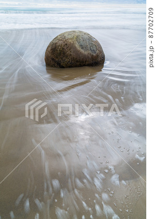 ニュージーランド　モエラキの海岸にある丸い奇石、モエラキ・ボルダーズと打ち寄せる波 87702709