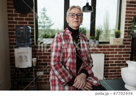 Portrait of senior teacher standing on chair in creativity studio 87702939