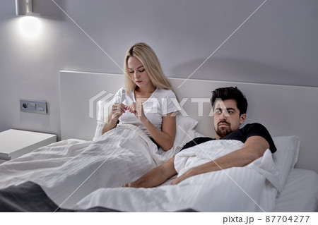 Furious Caucasian Woman And Man During Argue At Home, Sitting On Bed Not Talking 87704277