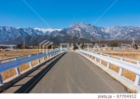 乳川に架かる橋より有明山と山麓を撮る【北安曇郡松川村】 87704912
