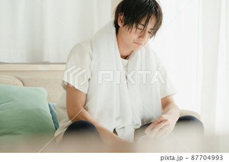 濡れた髪をタオルで乾かす若い男性 濡れた髪をタオルで乾かす若い男性 87704993