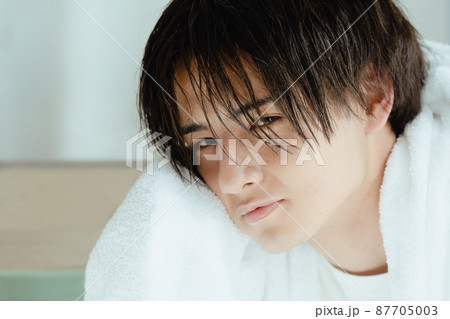 濡れた髪をタオルで乾かす若い男性 87705003