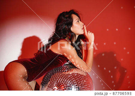 Young woman salsa dancer posing under a red projector's light Young woman salsa dancer posing under a red projector's light 87706593