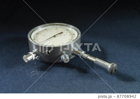 Mechanical tachometer with arrow on black background 87708942