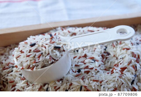 Brown and White Jasmine Rice on Measuring Spoon 87709806