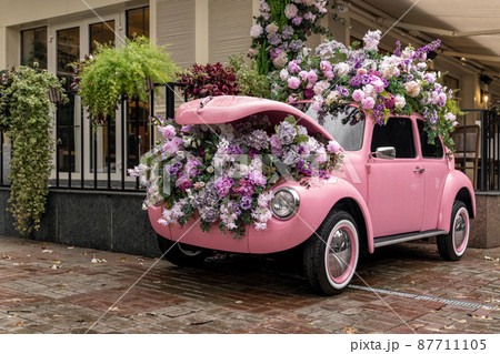 Vintage colorful auto loaded with flowers and transformed into decoration Vintage colorful auto loaded with flowers and transformed into decoration 87711105
