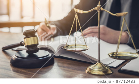 Male lawyer or judge working with contract papers, Law books and wooden gavel on table in courtroom, Justice lawyers at law firm, Law and Legal services concept 87712433