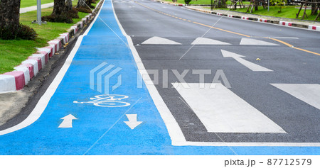 Blue bicycle lane on road with white bicycle icon and arrow. Empty Bicycle way for bike. Blue bicycle lane on road with white bicycle icon and arrow. Empty Bicycle way for bike. 87712579