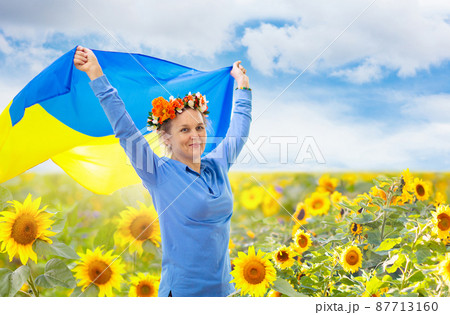 Pray for Ukraine. Woman with Ukrainian flag. 87713160