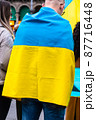 Young man wrapped in the Ukrainian flag in a protest against Russia invasion 87716448