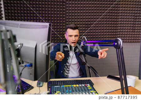cheery radio in a shirt host broadcasts live reads news on computer screen. 87717395