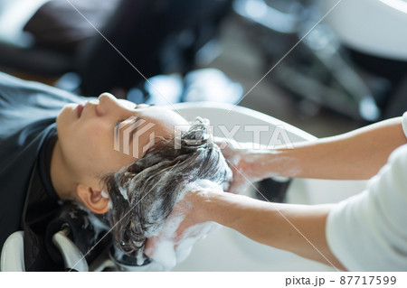 美容室でシャンプーしてもらう女性 87717599