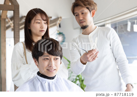 カットを教える先生と若いスタッフ 87718119