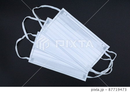 白い不織布マスク　予防イメージ　黒バック 87719473