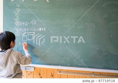 黒板に何かを書く生徒 87719516