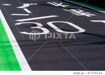 陽の当たる路面に書かれた道路標示　ゾーン30と止まれ 87720123