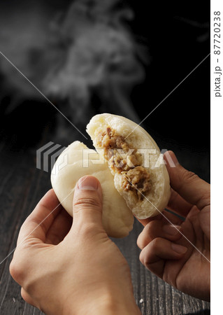 手で割って断面が見える熱々の肉まん 87720238