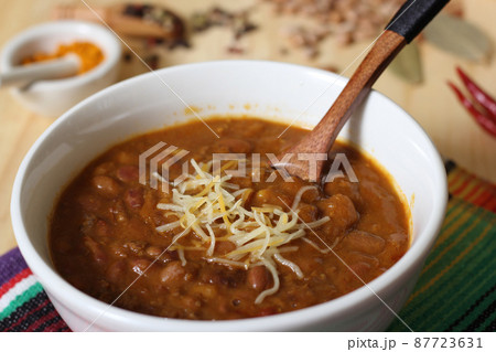 Bowl of Chili With Pinto Beans on Table With Peppers and Dry Beans in Background Bowl of Chili With Pinto Beans on Table With Peppers and Dry Beans in Background 87723631