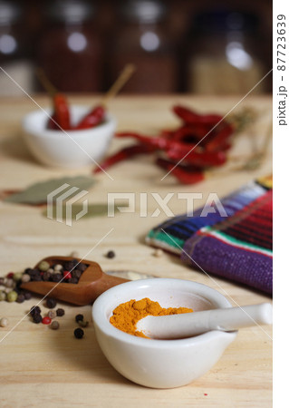 Mortar and Pestle With Turmeric and Chili Peppers 87723639