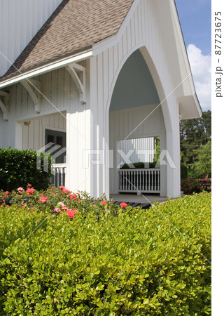 Small White Church Building Close up With Hedges and Roses Small White Church Building Close up With Hedges and Roses 87723675