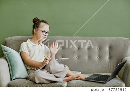 Girl with Down Syndrome using Laptop at Home Girl with Down Syndrome using Laptop at Home 87725912