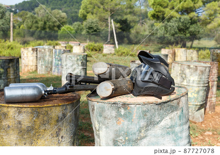 Protective masks and marker guns on paintball field Protective masks and marker guns on paintball field 87727078