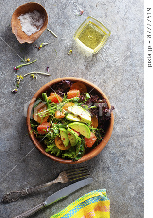 Healthy vegan salad, avocado, cucumber, tomato, radish, nuts and seeds. Girl in denim shirt holding a bowl of vegan salad Healthy vegan salad, avocado, cucumber, tomato, radish, nuts and seeds. Girl in denim shirt holding a bowl of vegan salad 87727519
