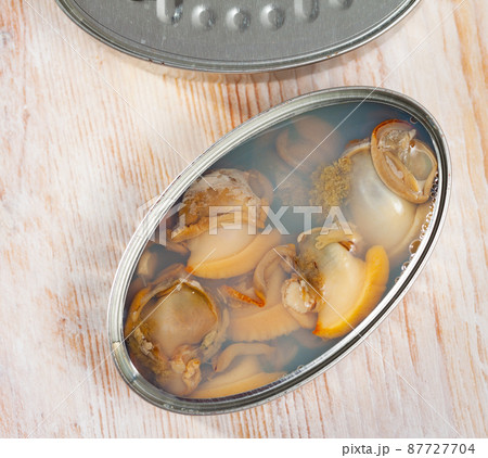 Marinated shellfish in an open tin can on wooden table Marinated shellfish in an open tin can on wooden table 87727704
