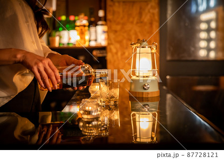 バーカウンターでお酒を提供する女性　BAR 87728121