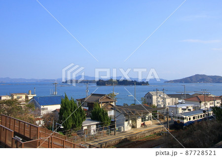 ローカル線の駅から西に向かって出発する観光列車 87728521