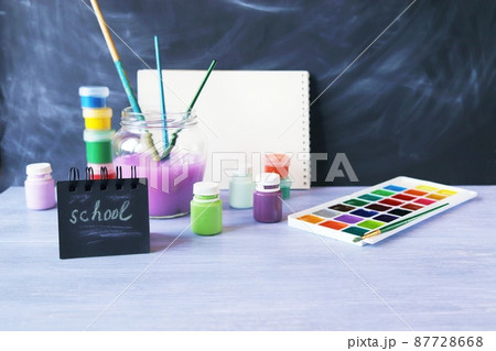 Drawing learning supplies on table, stack of books on chalkboard background, back to school Drawing learning supplies on table, stack of books on chalkboard background, back to school 87728668
