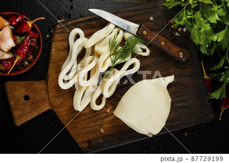 Slicing of boiled calamar on a cook-table 87729199