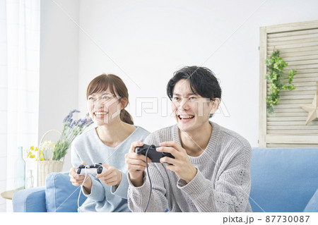 テレビゲームで遊ぶ男女 テレビゲームで遊ぶ男女 87730087